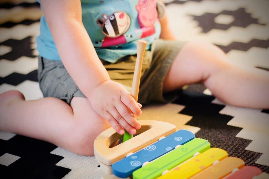 Toddler playing with a toy xylophone in music class